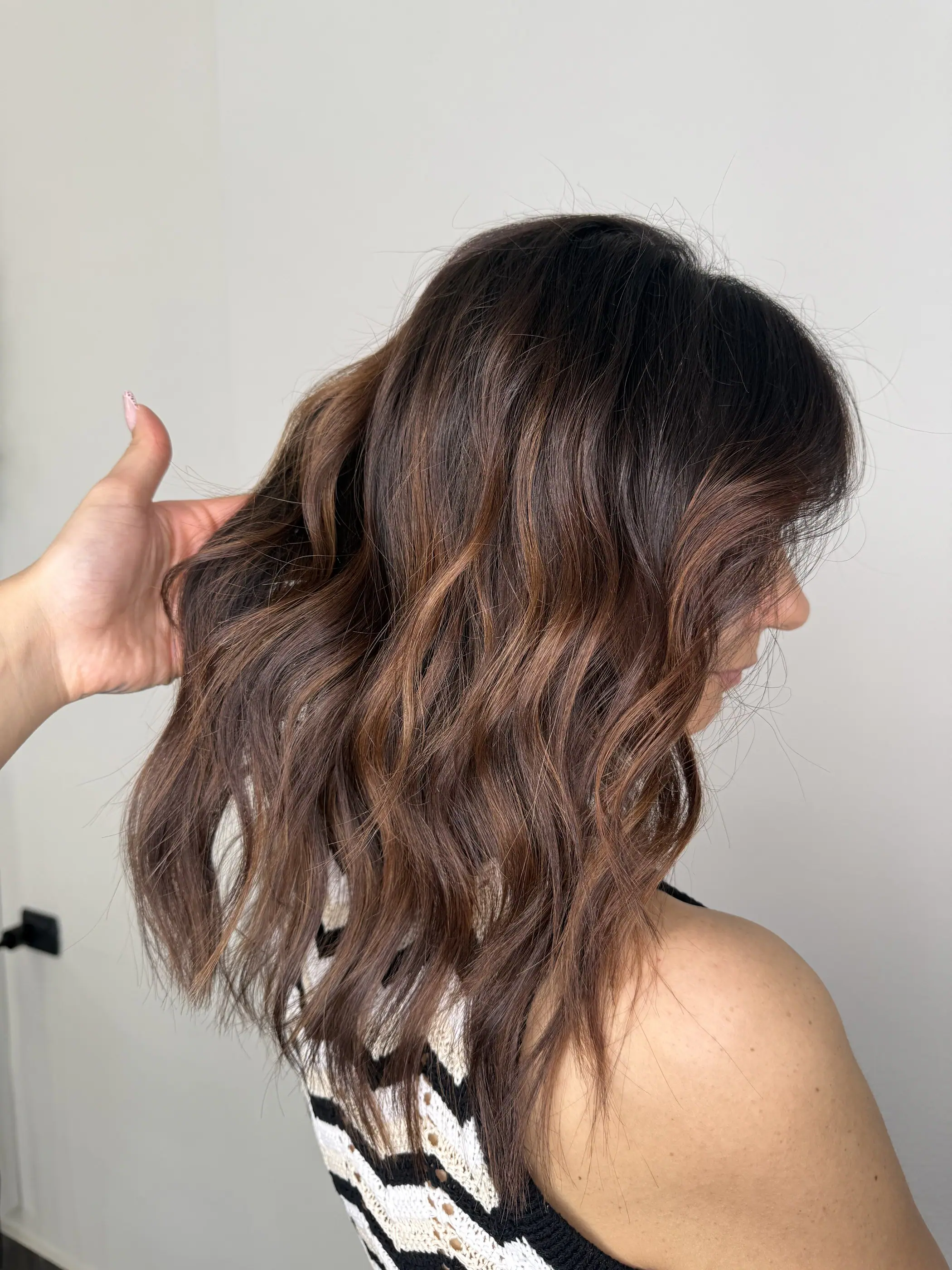 Capelli castani mossi con riflessi caldi, visti di profilo